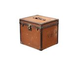 une vieille valise posée sur une surface blanche
