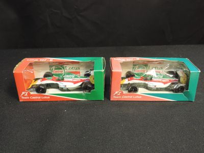 two boxed boxes with two racing cars in them on a black surface