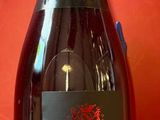 des bouteilles de vin posées sur une table rouge, sur fond rouge