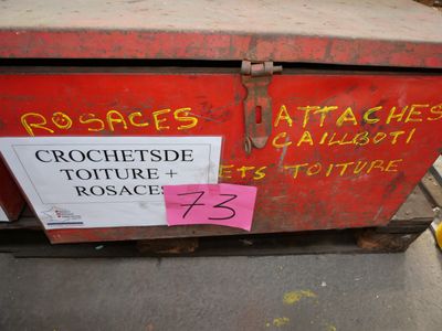 une boîte rouge sur laquelle est écrit quelque chose, posée sur le trottoir