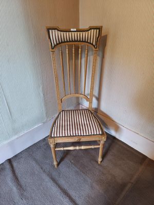 a chair with a striped seat in a corner of a room