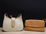 two purses sitting on top of a table next to each other