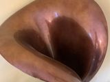 a brown vase sitting next to a toilet in a bathroom