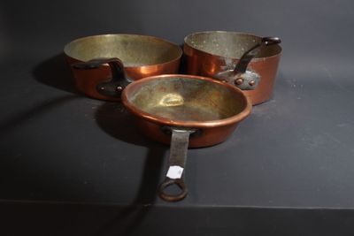 three pots and pans sitting on a black surface