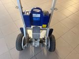 an image of a blue hand truck with wheels on a tiled floor