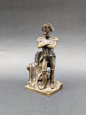 statue of a man sitting on a stump with a dog on his lap