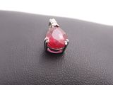 a close up of a red tear shaped stone on a black purse