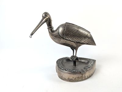 figurine de pélican plaquée argent sur socle, sur fond blanc