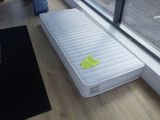 un matelas posé à même le sol près d'une fenêtre