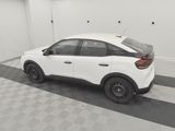 a white car parked in a garage with a checkered floor
