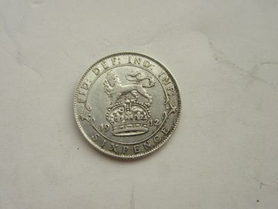 une pièce d'argent sur laquelle figure une couronne, posée sur un fond blanc