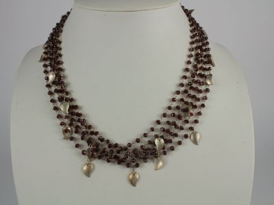 brown beaded necklace with silver leaf charms on a white mannequin