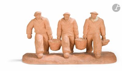 trois figurines représentant des hommes portant des paniers, posées sur une surface blanche