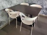 a table and chairs in a room with a wall painted with marble