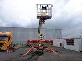 a man on a cherry picker in the middle of a parking lot