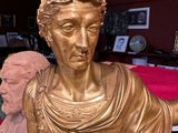a gold statue of a man holding a bird