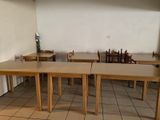 tables and chairs in a room with a tiled floor and a white wall