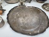a silver plate sitting on a table next to other silver objects