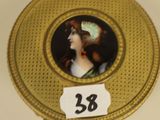 a gold plate with a picture of a woman on it