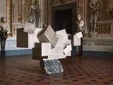 a sculpture made out of boxes on a pedestal in a room