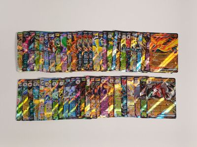 Plusieurs types différents de cartes Pokémon sont alignées sur une surface blanche