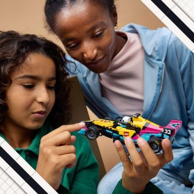 a woman and a young girl playing with a toy car