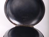 a small black box with a black lid on a white surface