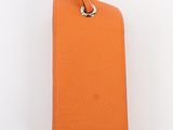 an orange leather luggage tag on a white background