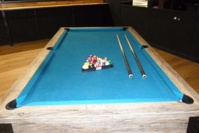 une table de billard recouverte d'un tapis bleu, sur laquelle se trouvent deux boules de billard