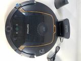 a black and yellow robotic vacuum cleaner on a table