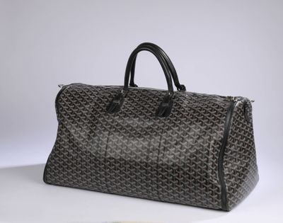 a brown and black duffel bag sitting on top of a white table