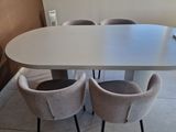 a white table with four chairs and a laptop on it
