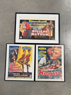 trois affiches de cinéma encadrées représentant un homme et une femme, accrochées au mur