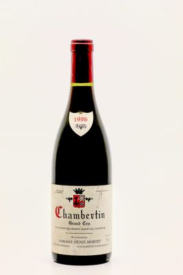 une bouteille de vin rouge posée sur une table blanche