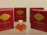 three small bottles of perfume sitting on top of a glass table
