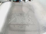 a silver plate with a design on it on a table