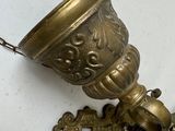 a small brass bell on a chain next to a key