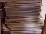 a lot of newspapers stacked on a shelf in a room