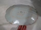 a hand holding a white plate on a white surface