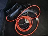 a cord and a charger sitting on the floor next to a suitcase