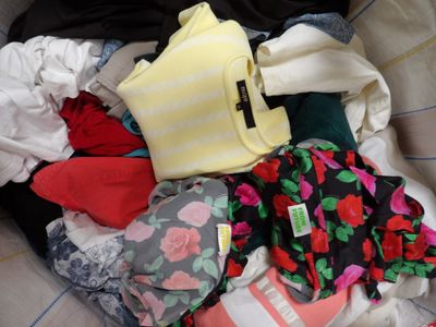 a pile of clothes in a basket on a bed