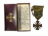 un vieux livre sur lequel figurent une croix et une médaille
