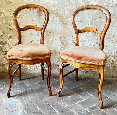 two chairs sitting next to each other on a brick floor