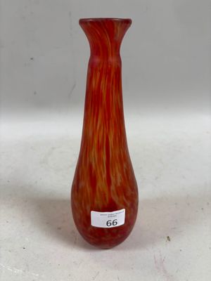 un vase en verre rouge posé sur une surface blanche