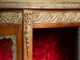 an antique wooden cabinet with a red velvet upholstered seat