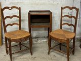 two chairs and a table in front of a white brick wall