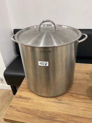 a large stainless steel pot sitting on top of a wooden table