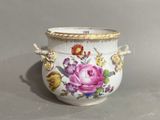a white vase with a floral design on it