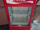 une glacière Coca-Cola posée par terre dans la cuisine