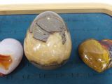 three rocks on a tray with a heart shaped rock